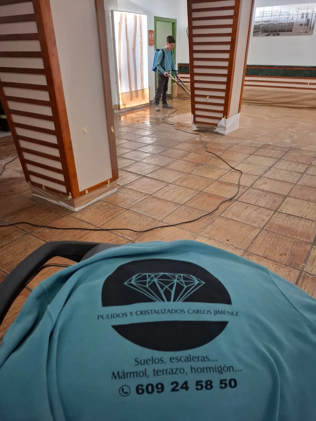 Operario de Pulimentos Jiménez, con la camiseta de la empresa, tratando un suelo de barro cocido