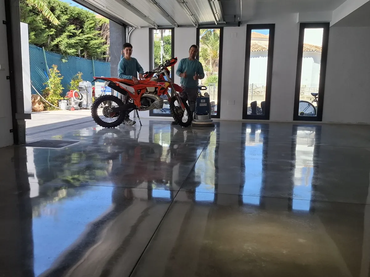 El equipo de Pulimentos Jiménez con clientes sobre un garaje de hormigón pulido con acabado espejo