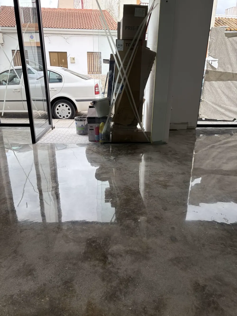 Local con hormigón pulido gris espejo, entrada con coche — trabajo real de Pulimentos Jiménez