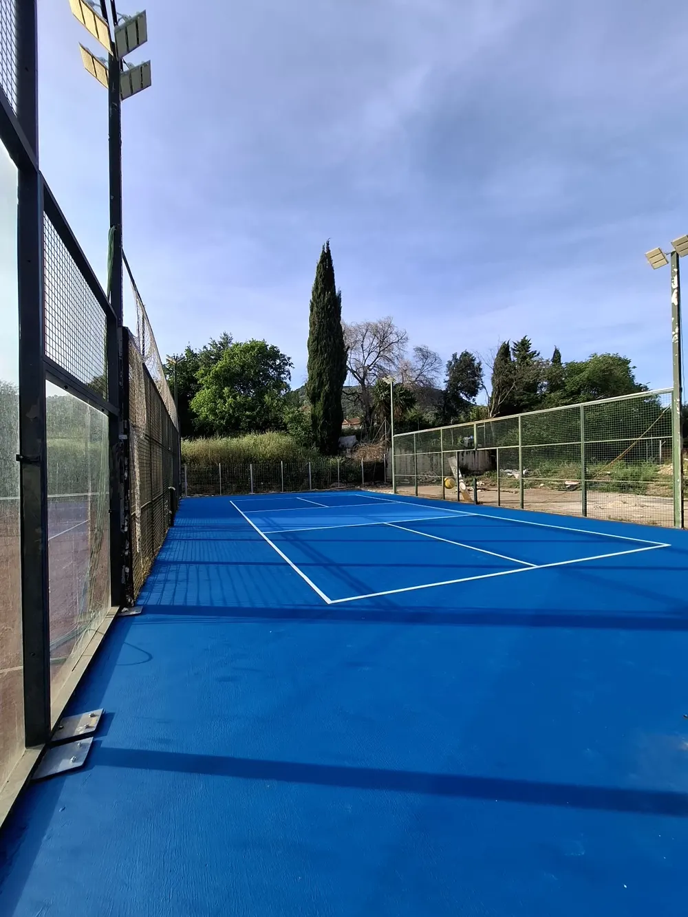 Pista pádel/tenis azul terminada, vista general — trabajo real de Pulimentos Jiménez