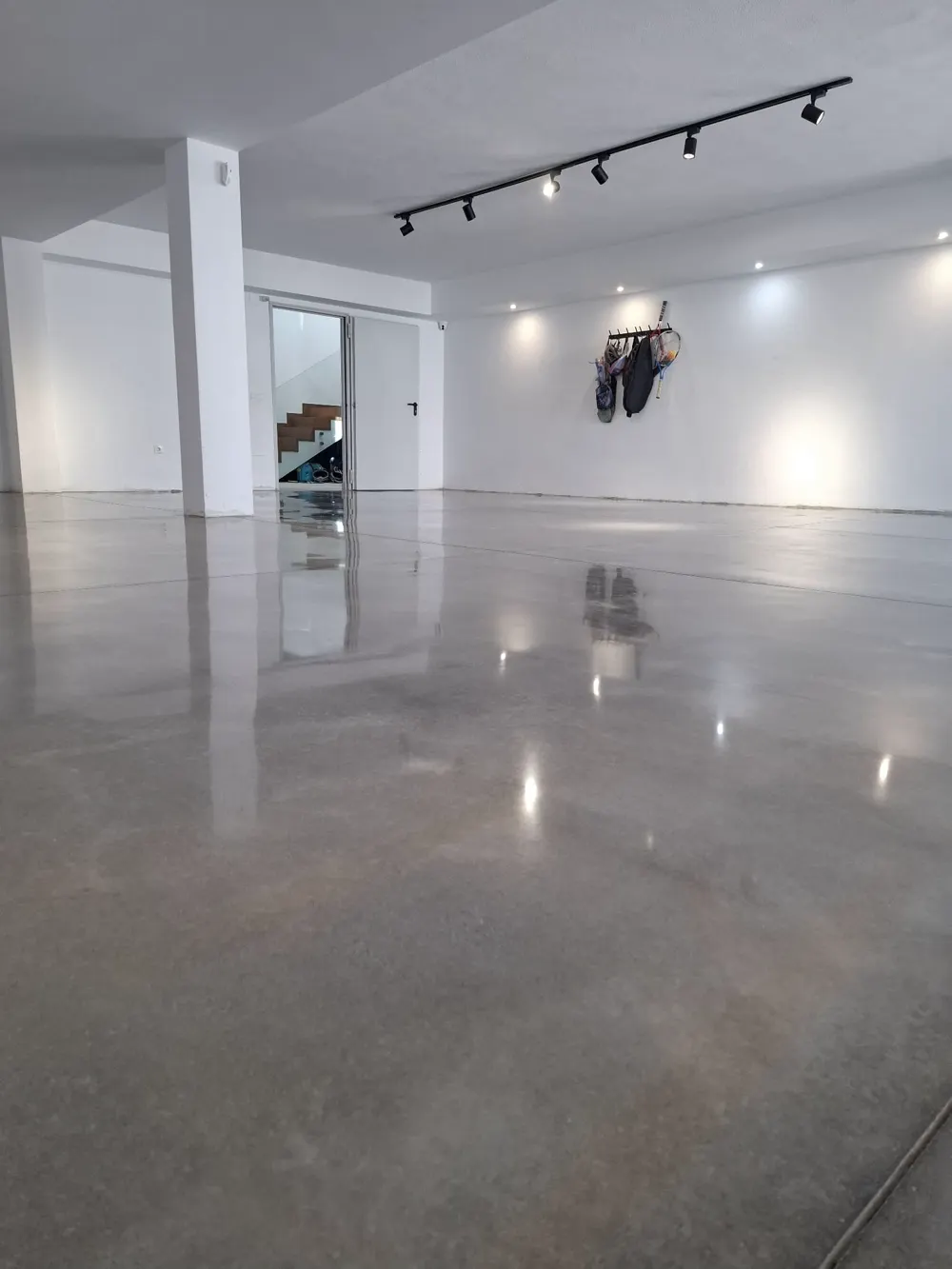 Gran salón con hormigón pulido gris impecable y focos — trabajo real de Pulimentos Jiménez