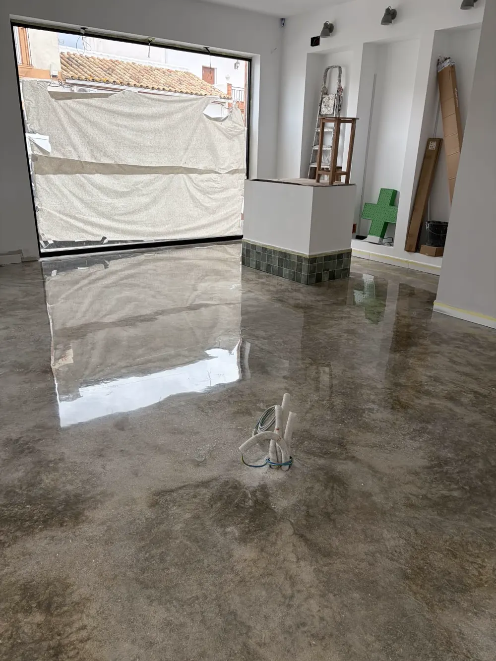 Local en obra, microcemento gris pulido reflectante — trabajo real de Pulimentos Jiménez