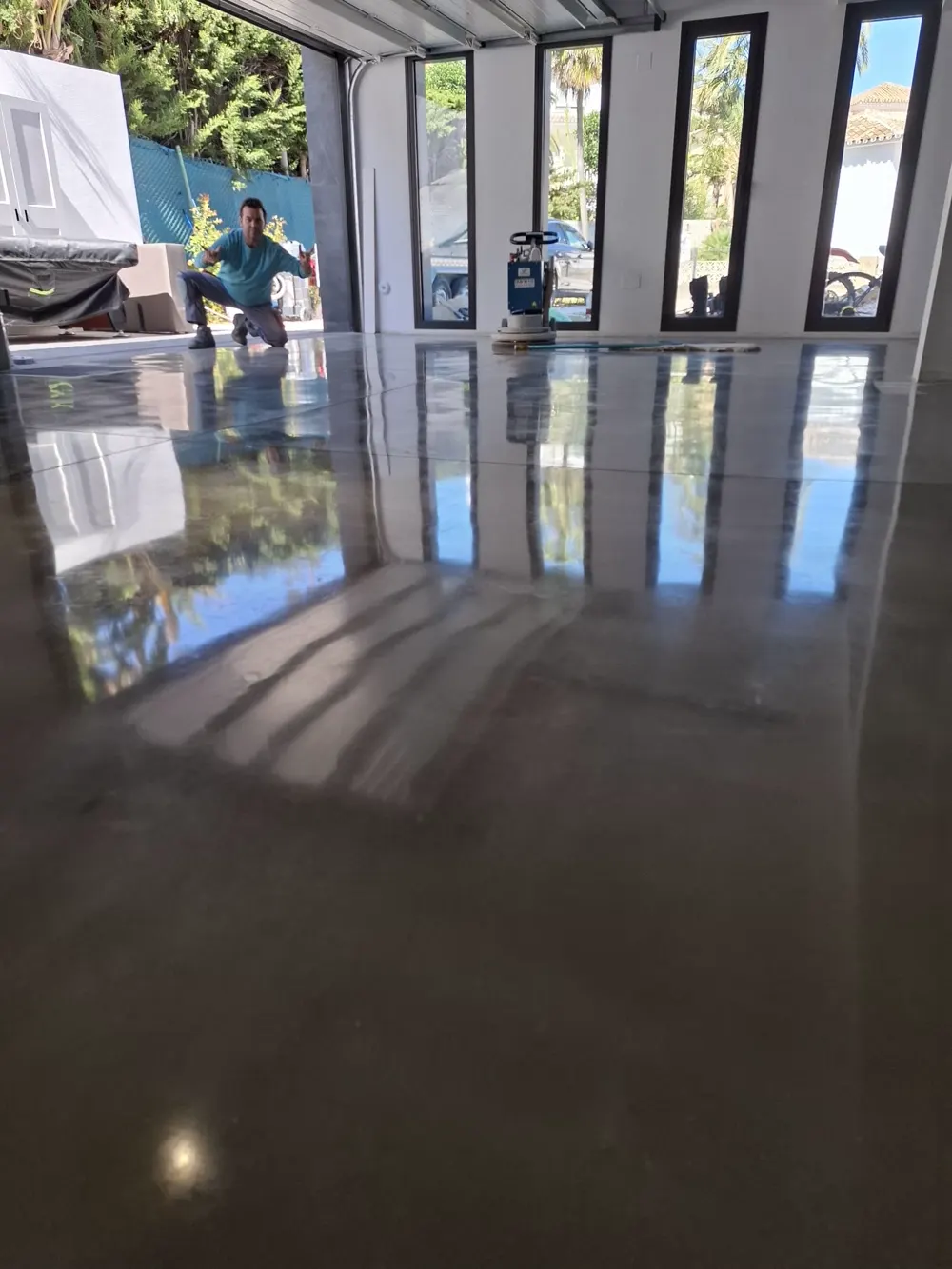 Garaje vivienda brillo espejo, operario posando al fondo — trabajo real de Pulimentos Jiménez