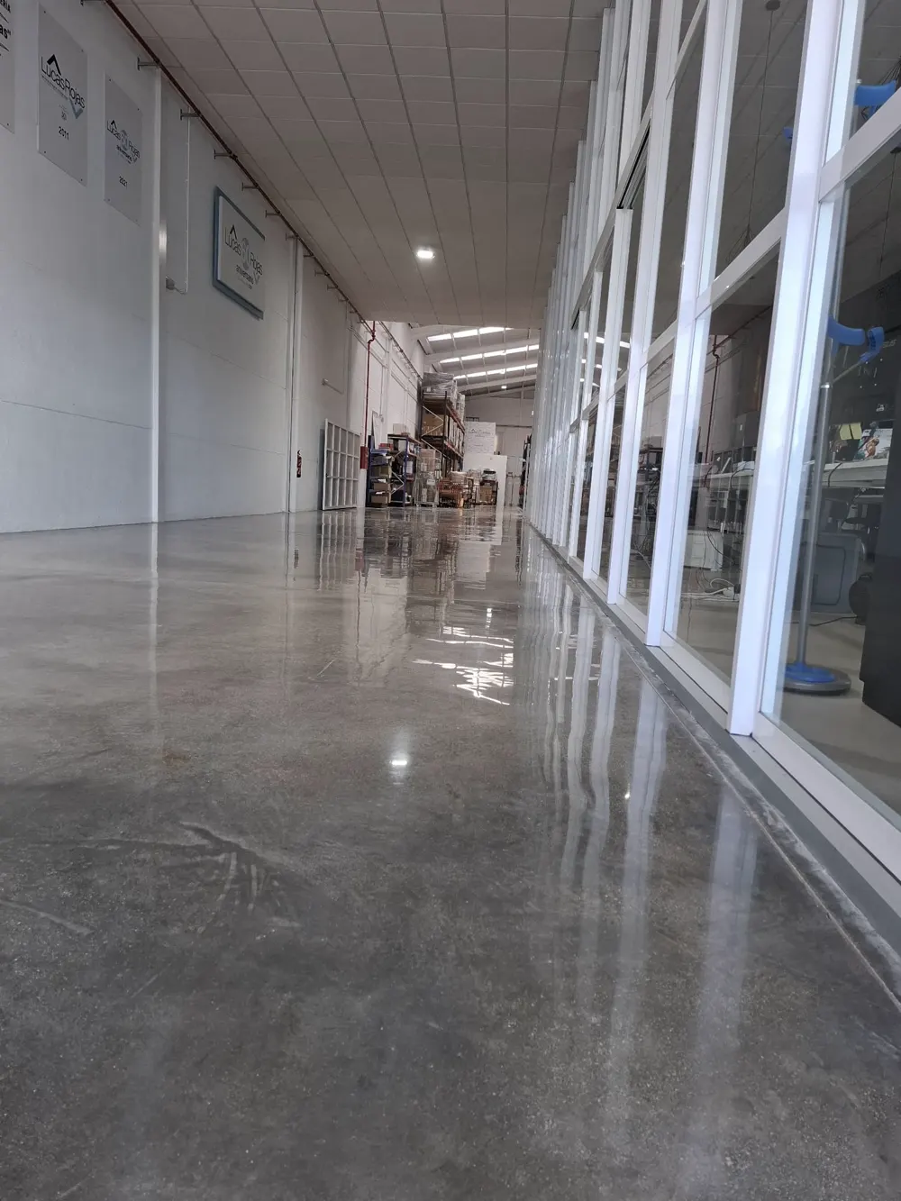 Pasillo de nave con hormigón pulido espejo junto oficinas — trabajo real de Pulimentos Jiménez