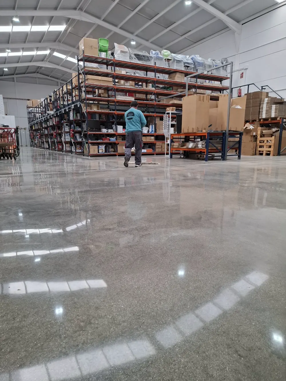 Nave logística con estanterías y suelo pulido reflectante — trabajo real de Pulimentos Jiménez