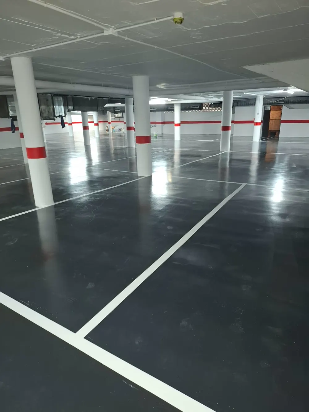 Parking pintado gris con líneas blancas nuevas, muy limpio — trabajo real de Pulimentos Jiménez